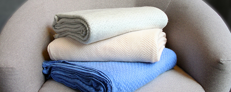 Plaid en cachemire gris, bleu et rose sur un canapé