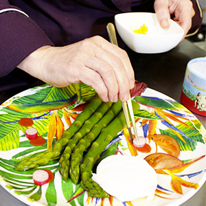 Karin Burton placant ses ingredients dans les assiettes en mélamine colorées des jardins de la comtesse au restaurant Lou Ferri 