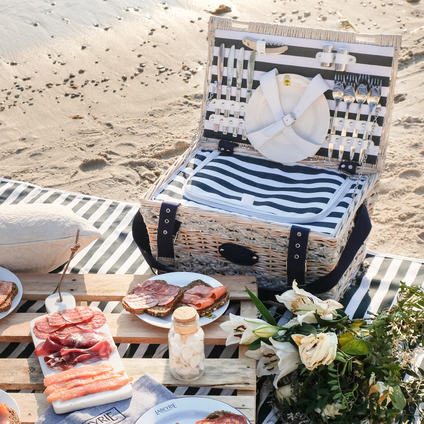 Panier pique-nique Marine 4 personnes en osier blanc avec cordages doublé d'un tissu à rayures bleues et blanches horizontales